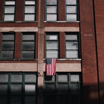 a brick building with a flag on the window