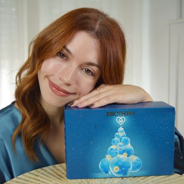a woman smiling and holding a laptop